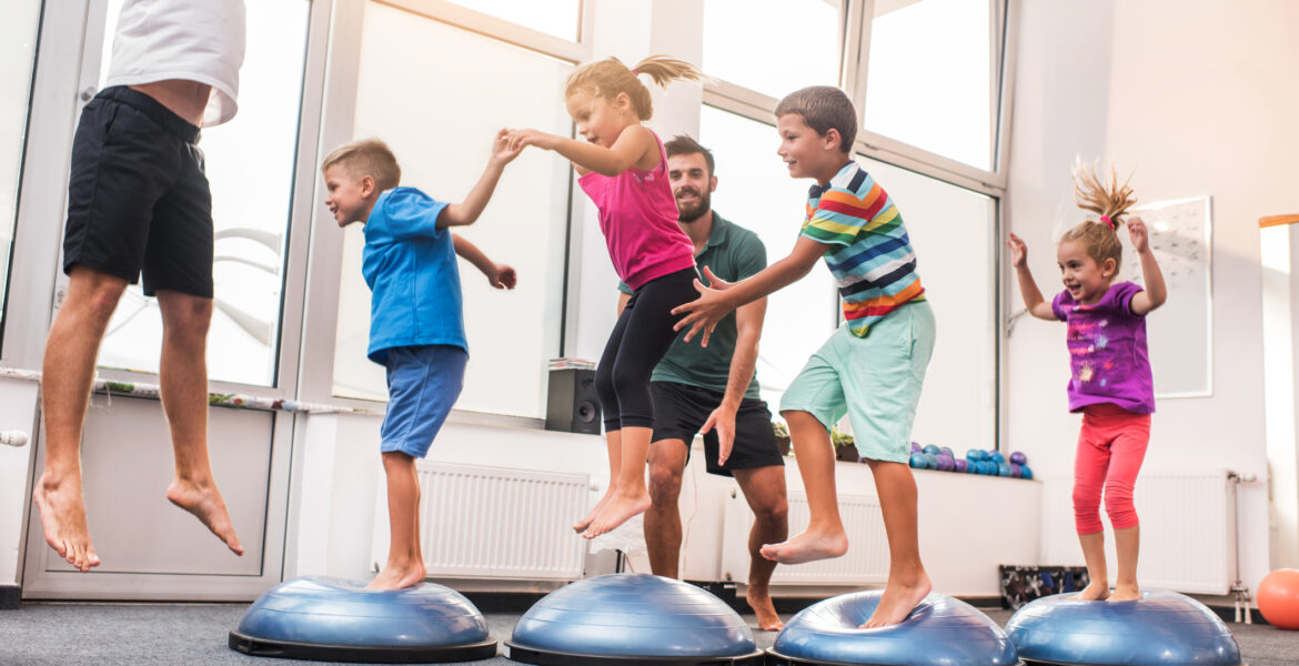 Small children jumping on bosu balls on training class.